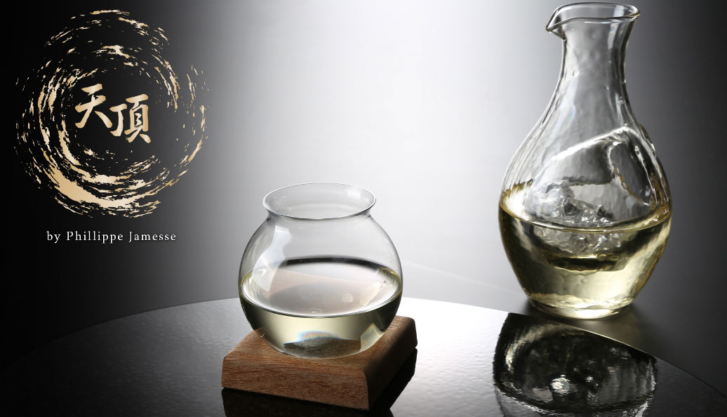 日本酒が注がれたグラスとガラス製の徳利の写真